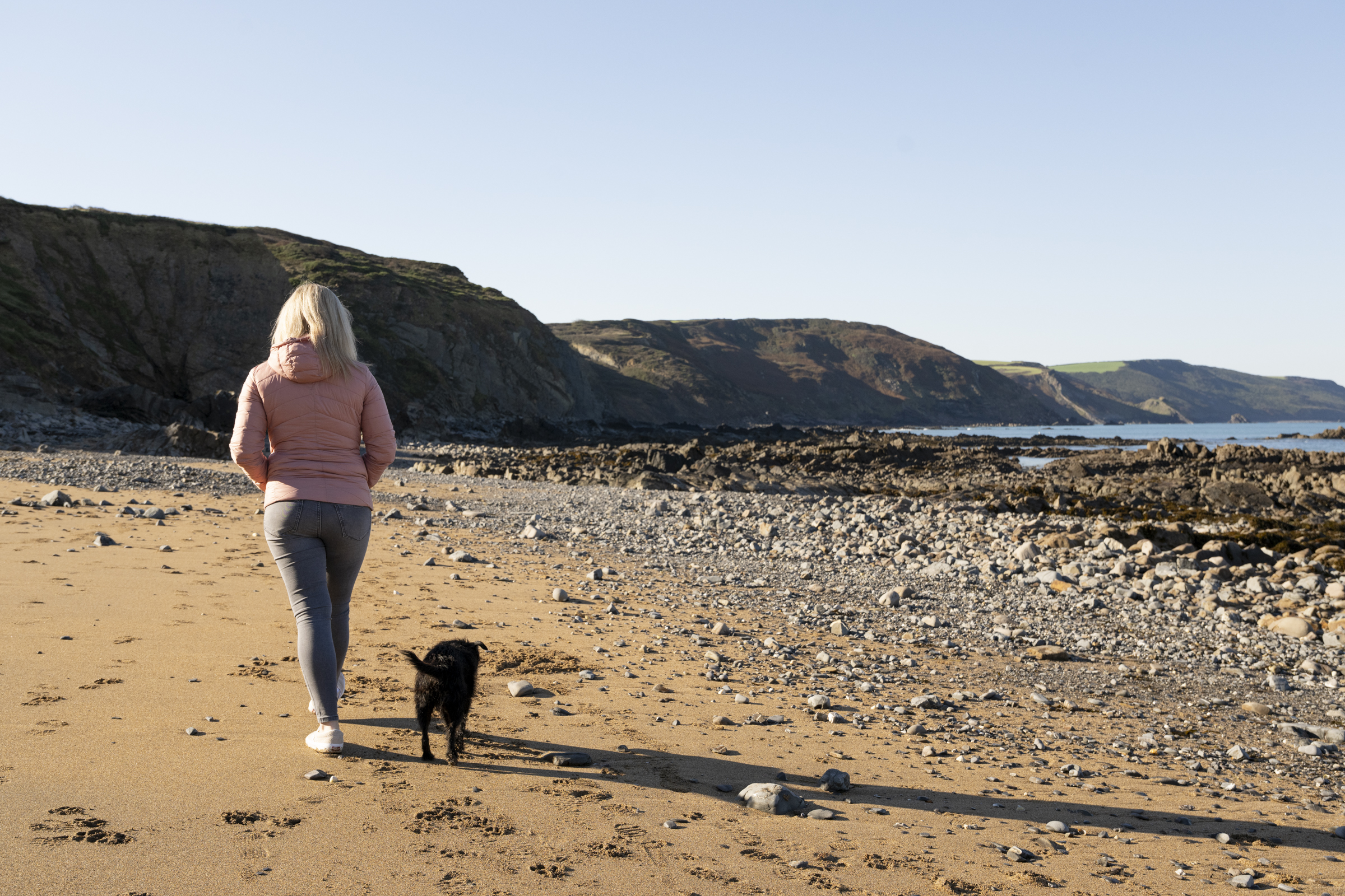 Women walking on the beach with her dog